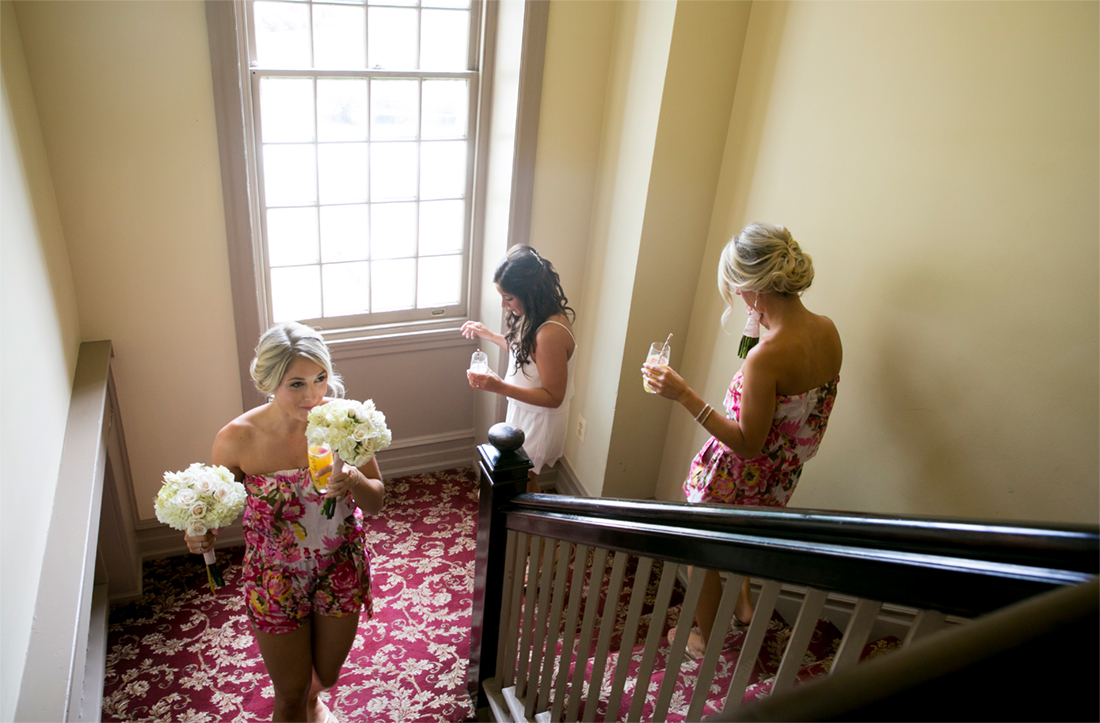 bridesmaids walking down the stairs in floral rompers at Normandy Farm