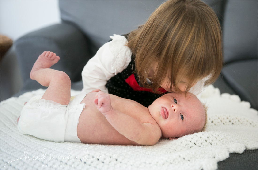 Newborn lifestyle photo session, lifestyle session, big sister kisses little brother, 