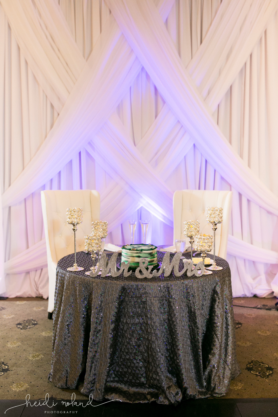 sweetheart table with purple uplighting and eagles cake