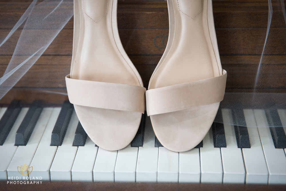 bride's wedding shoes on piano 