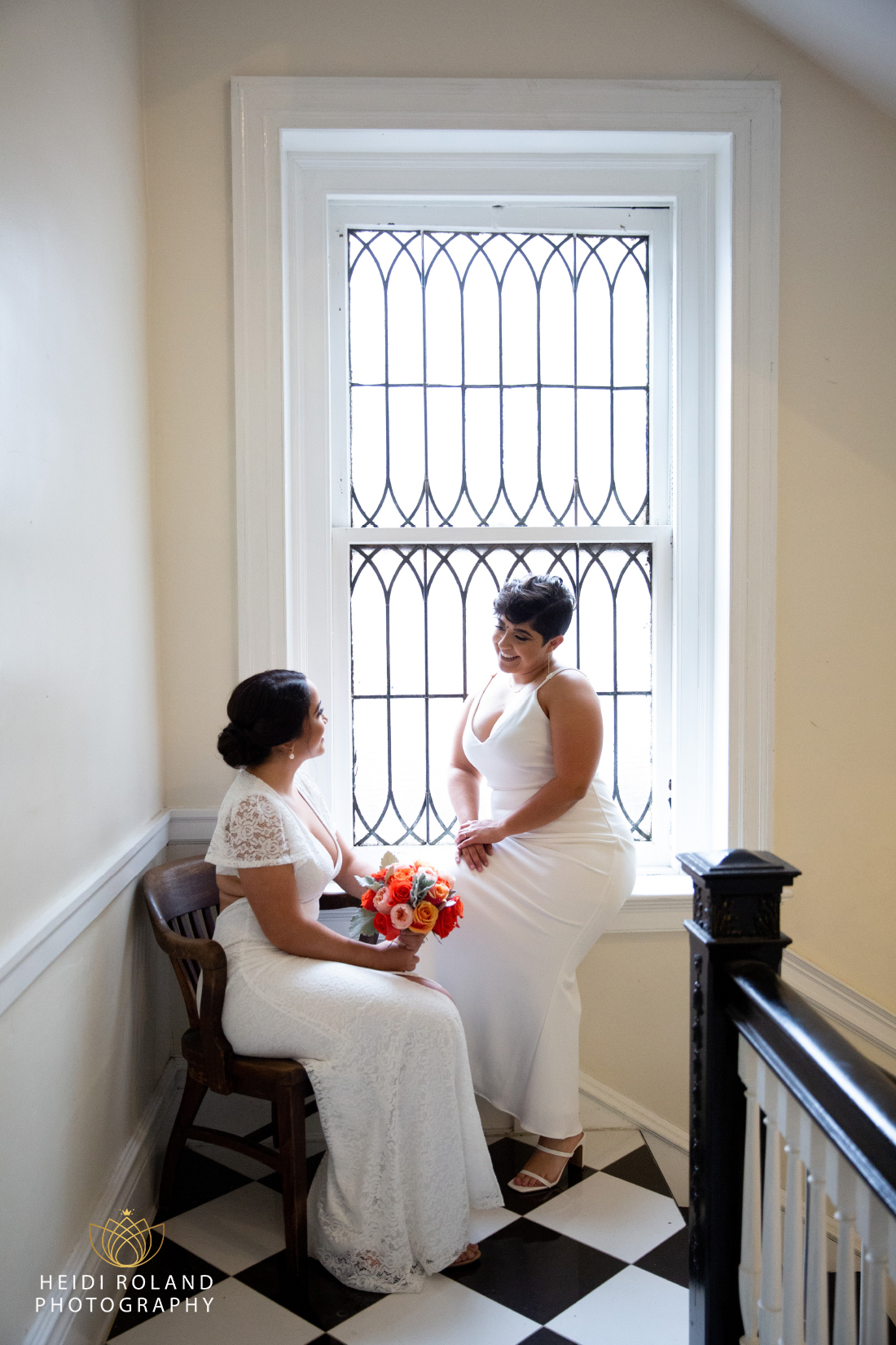 brides in front of vintage window at small Philadelphia wedding