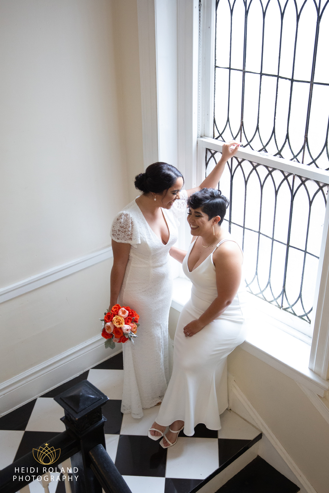 brides laughing near window and black and white floor
