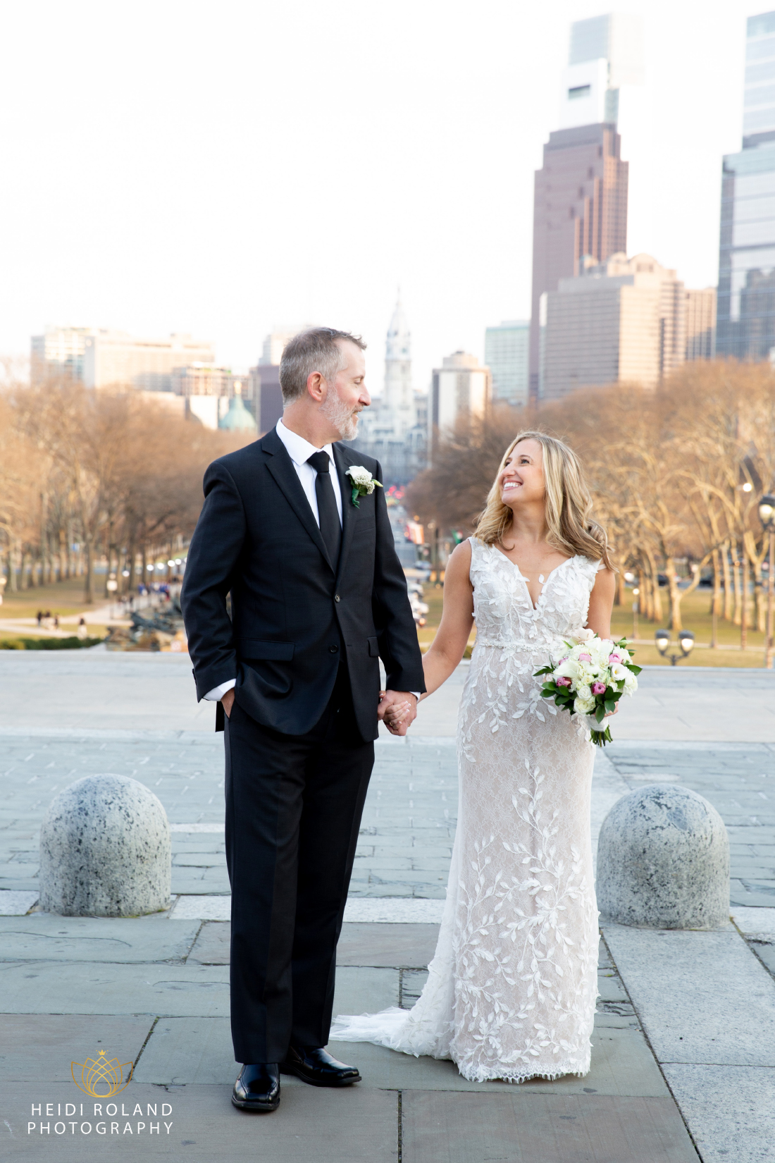 bride smiling at groom with philly skyline