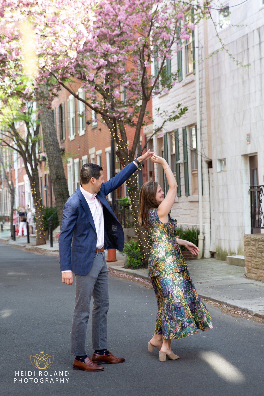 Man twirling woman on philadelphia street in the spring after proposal