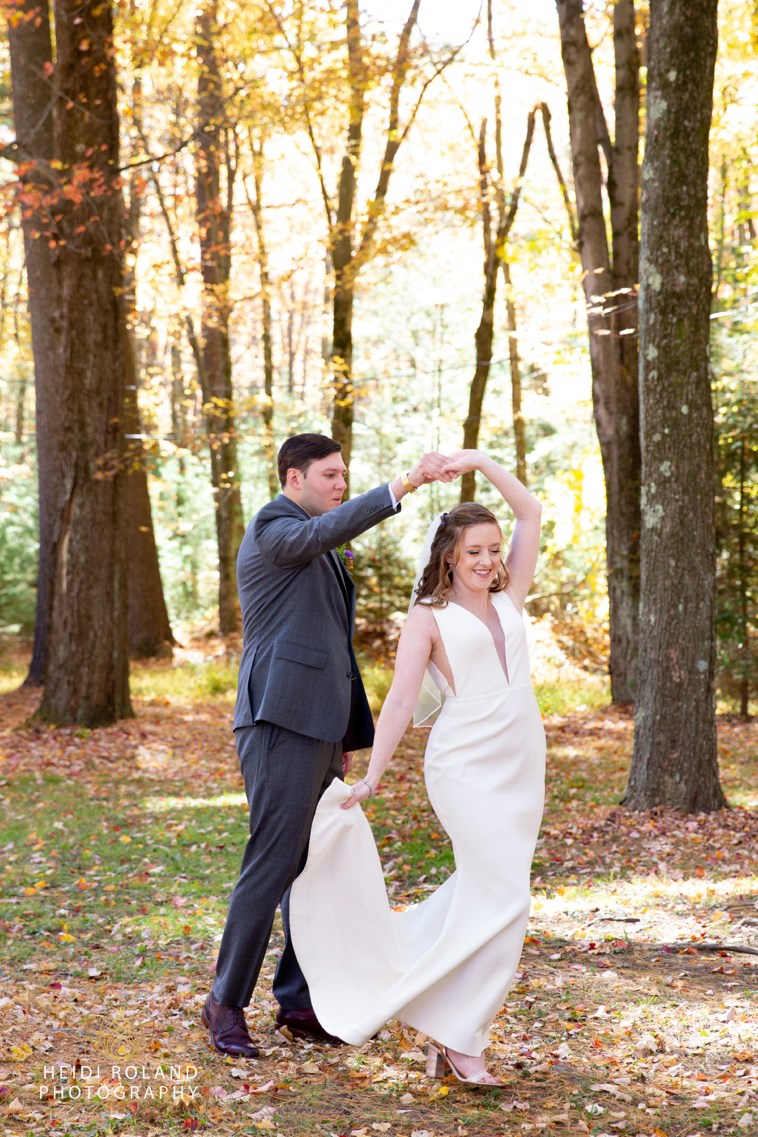 Groom spinning bride around in the woods before their mount Pocono wedding