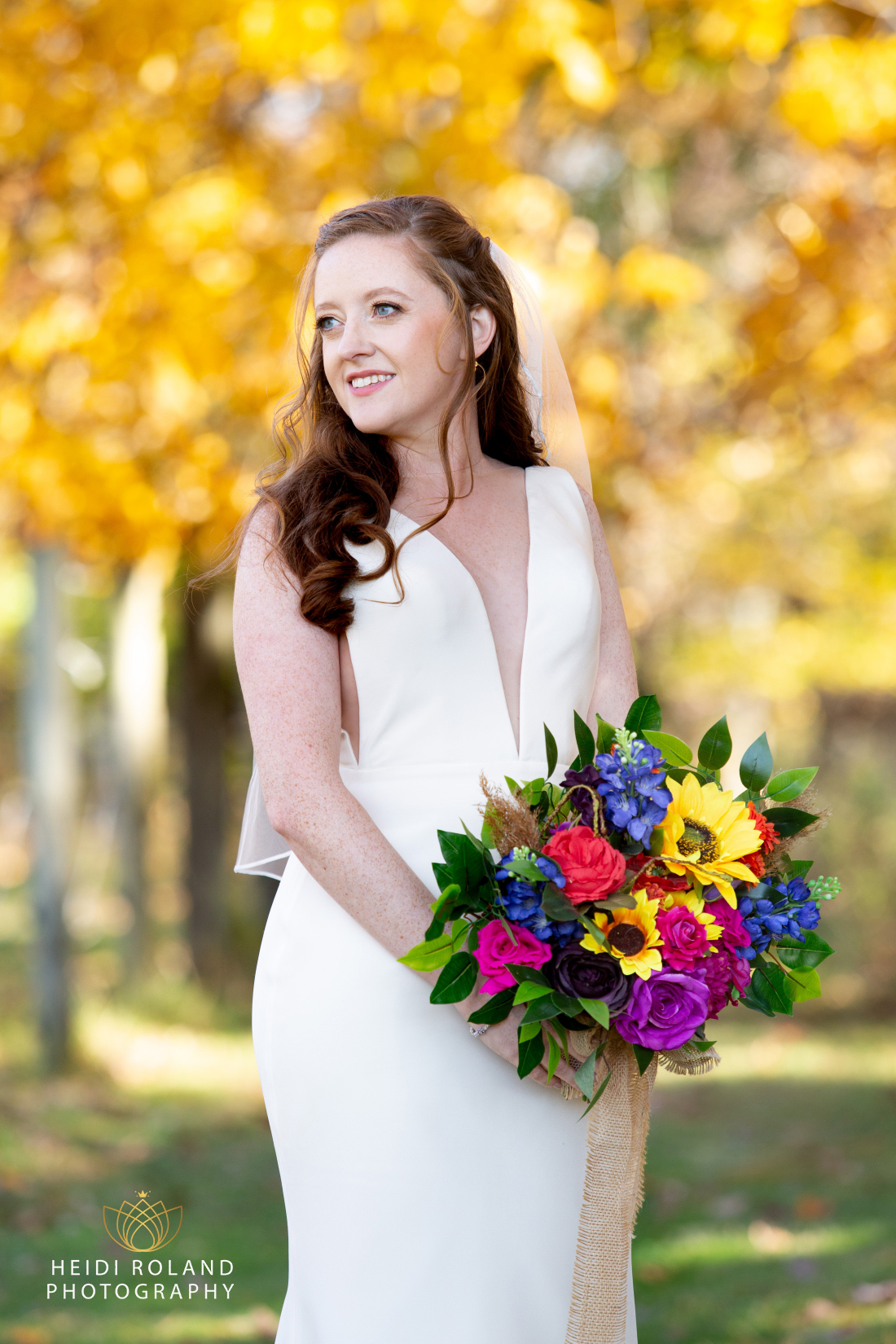 Portrait of bride at fall wedding holding a bright color flower bouquet in PA 