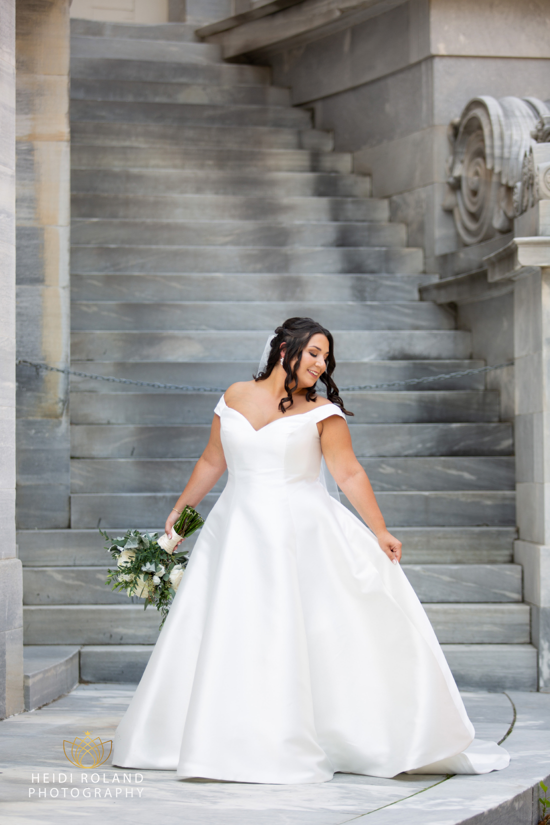 Bride in wedding dress by the steps of the Merchant Exchange building in philadelphia