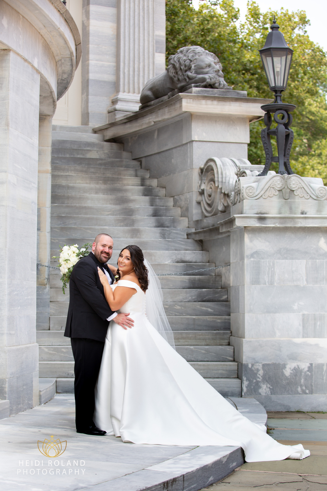 Portrait of bride and groom holding each other by the steps of the Merchant Exchange in Philly