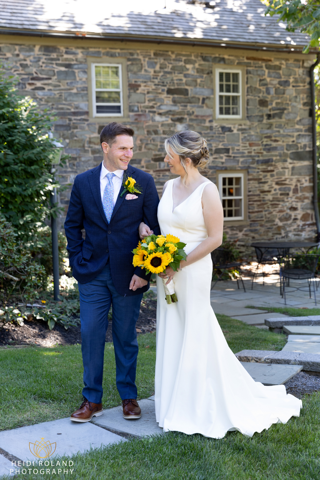 bride and groom walking down oath by stone building in Princeton NJ