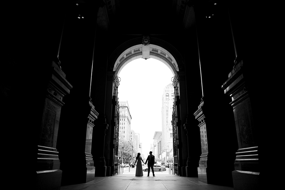 wedding photos under and archway of Philadelphia City Hall